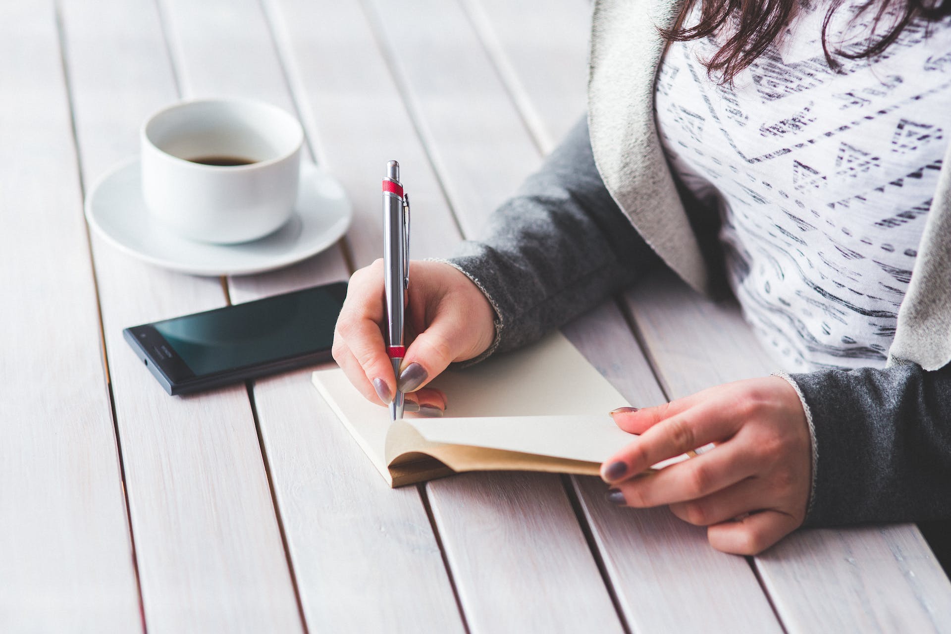 Woman's hand using a pen noting on notepad